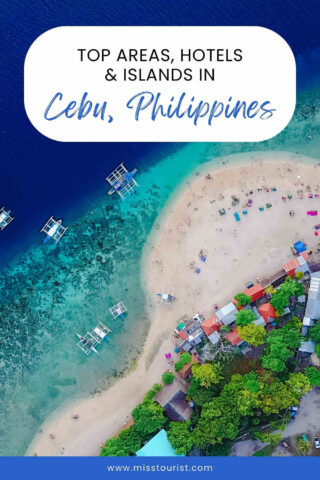 Aerial view of a sandy beach in Cebu, Philippines, with boats in the blue water and colorful beach umbrellas along the shore.