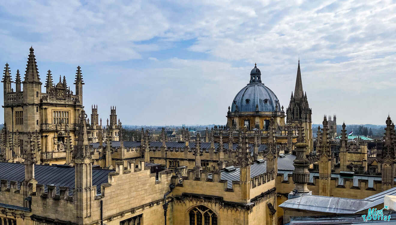 Skyline view of historic Oxford buildings with Gothic architecture, featuring spires and a large dome under a partly cloudy sky.