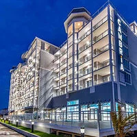 Night view of a modern, multi-story hotel building with illuminated balconies and a sign that reads "Cambria.