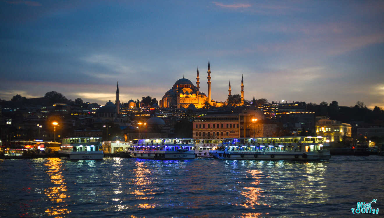 A night view of the Istanbul skyline features illuminated mosques and boats on the water, reflecting city lights.