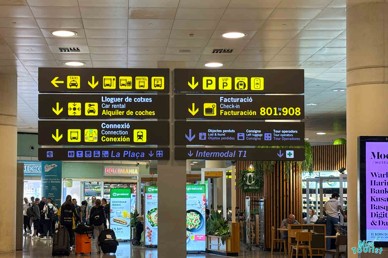 Airport signage directing to taxis, car rental, check-in (factors 801-908), connections, and public transport. Passengers and food outlets visible in the background.