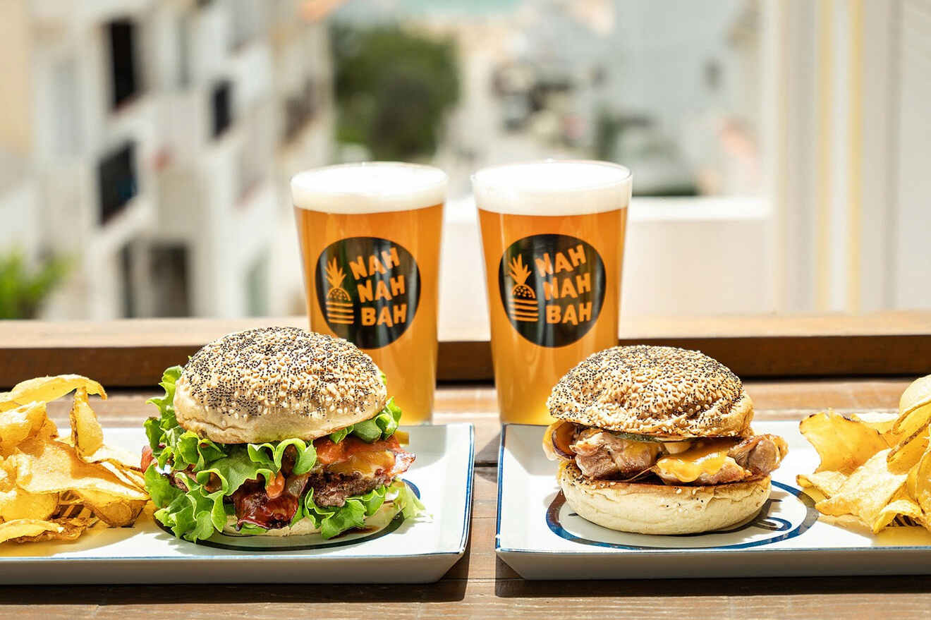 Two burgers and sides of chips on plates, with two beers in the background, each labeled "Nah Nah Bah.