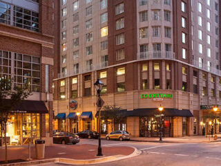 Street scene with cars parked and buildings featuring shops and a hotel labeled "Courtyard." Warm streetlights illuminate the area.