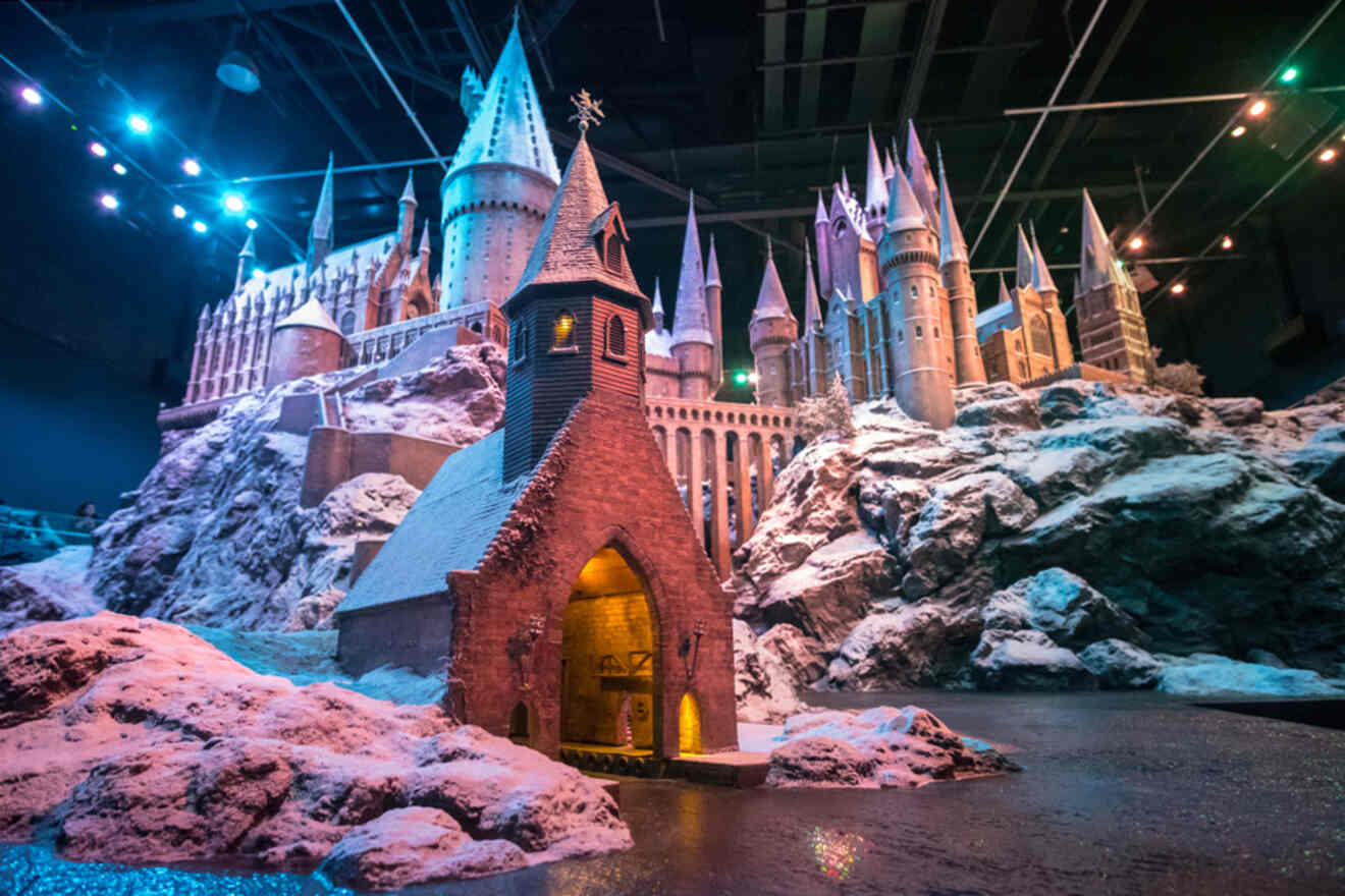 A model of a magical castle with towers and lights, surrounded by rocky terrain and snow.