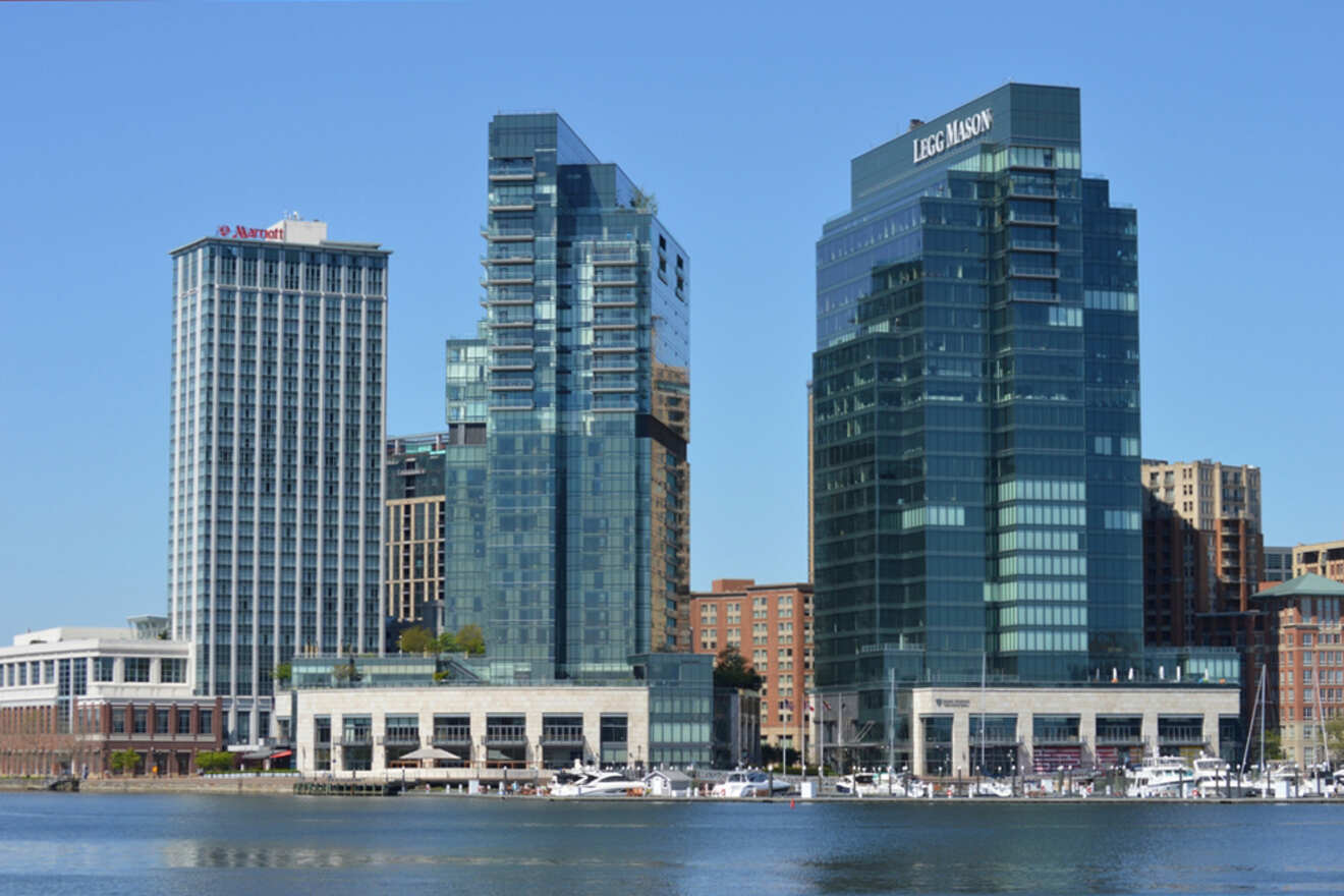 Skyline view of waterfront buildings, including a Marriott hotel and a Legg Mason building, under a clear blue sky.