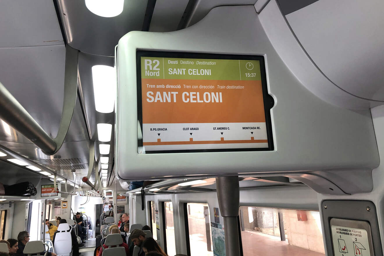 Train interior with passengers and a digital display showing 