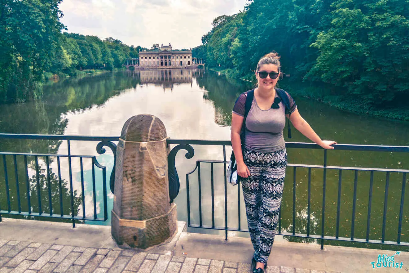 The writer of the post stands on a bridge next to a stone railing, with a large reflective pond and a historic building in the background.