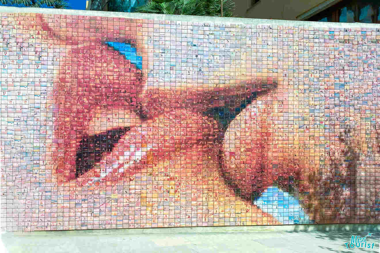 Mosaic mural depicting two faces close together against a backdrop of small colorful tiles.