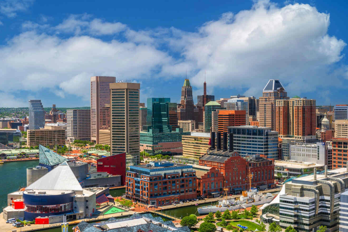 Aerial view of Baltimore's Inner Harbor with modern and historical buildings under a partly cloudy sky.