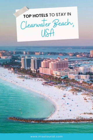 Aerial view of a beachside cityscape in Clearwater Beach, USA, with sandy shores, ocean, and hotels. A text overlay reads "Top Hotels to Stay in Clearwater Beach, USA.