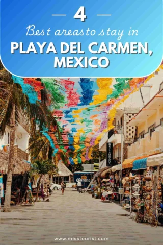 Street scene in Playa del Carmen, Mexico, with colorful banners hanging and shops lining the walkway.