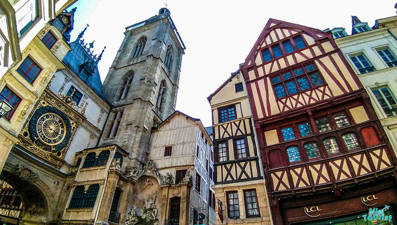 Historic buildings in Rouen, featuring the Gros-Horloge clock tower and half-timbered architecture under a clear sky.