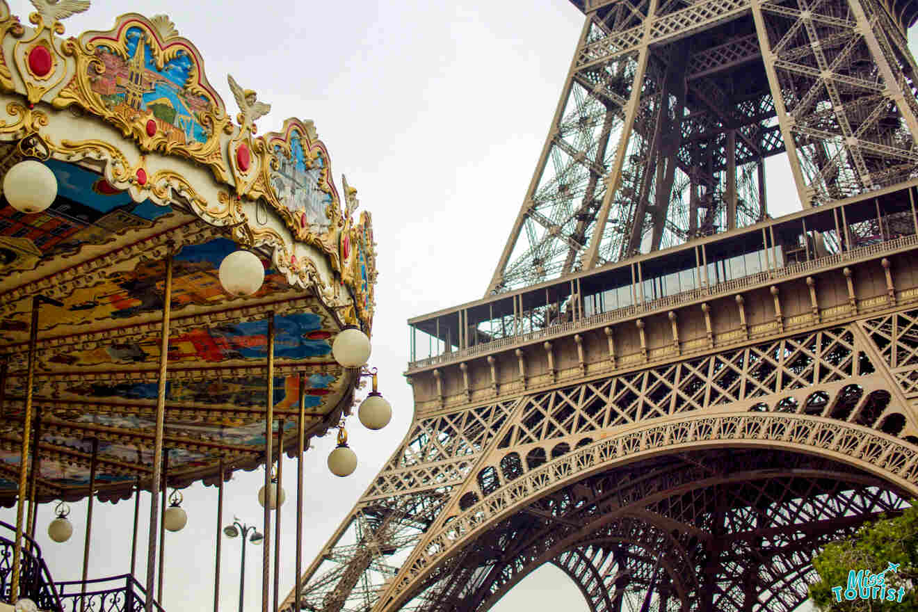 The image shows part of a colorful carousel next to the base of the Eiffel Tower in Paris.