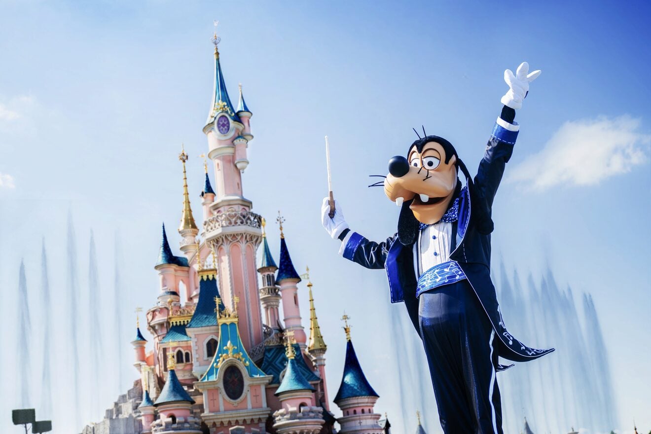 Goofy posing in front of Sleeping Beauty Castle at Disneyland Paris